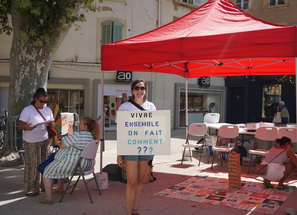 A caravaner holding a placard that reads : "How can we live together ?" 